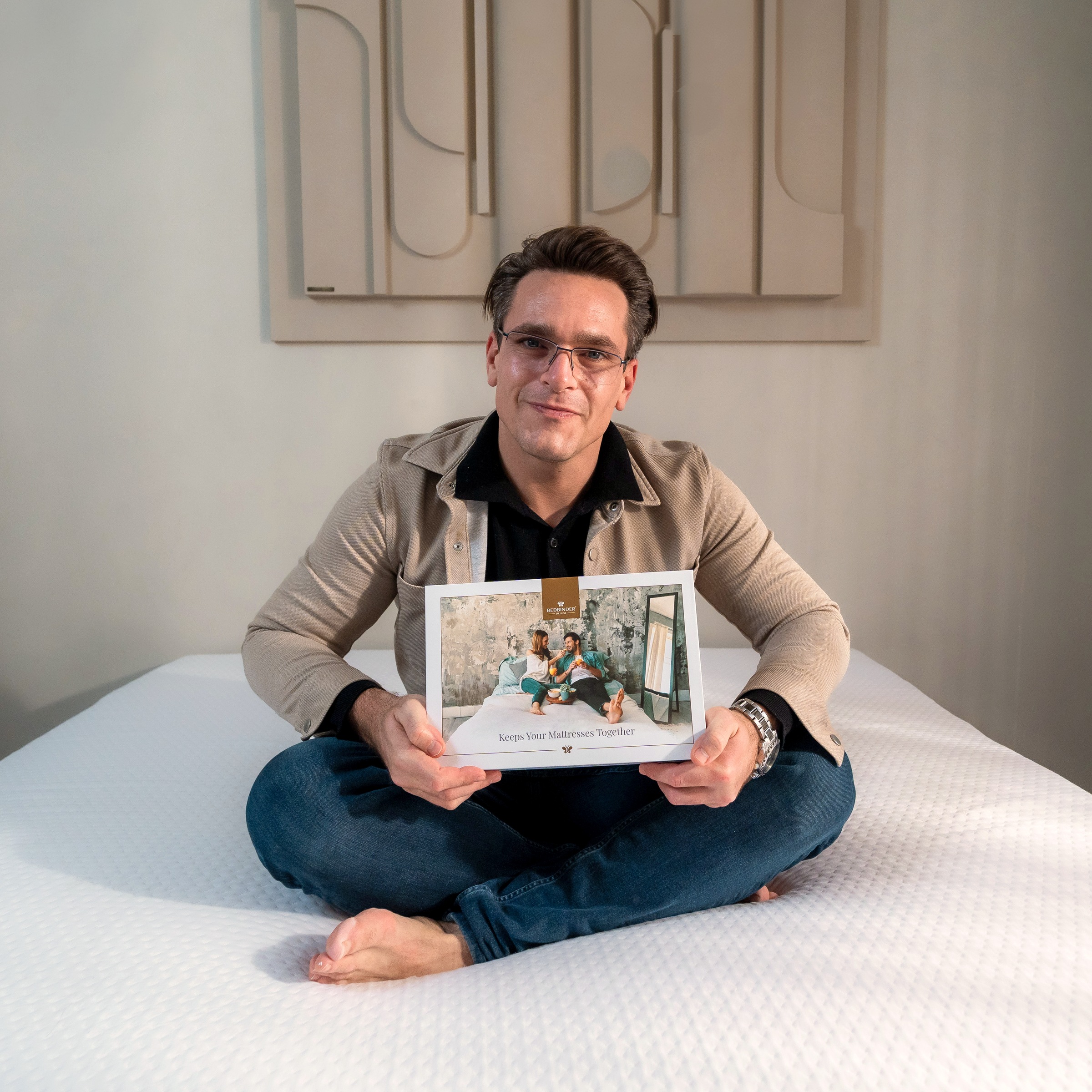 Daniël auf einem Bett mit der Verpackung des Bedbinder Deluxe