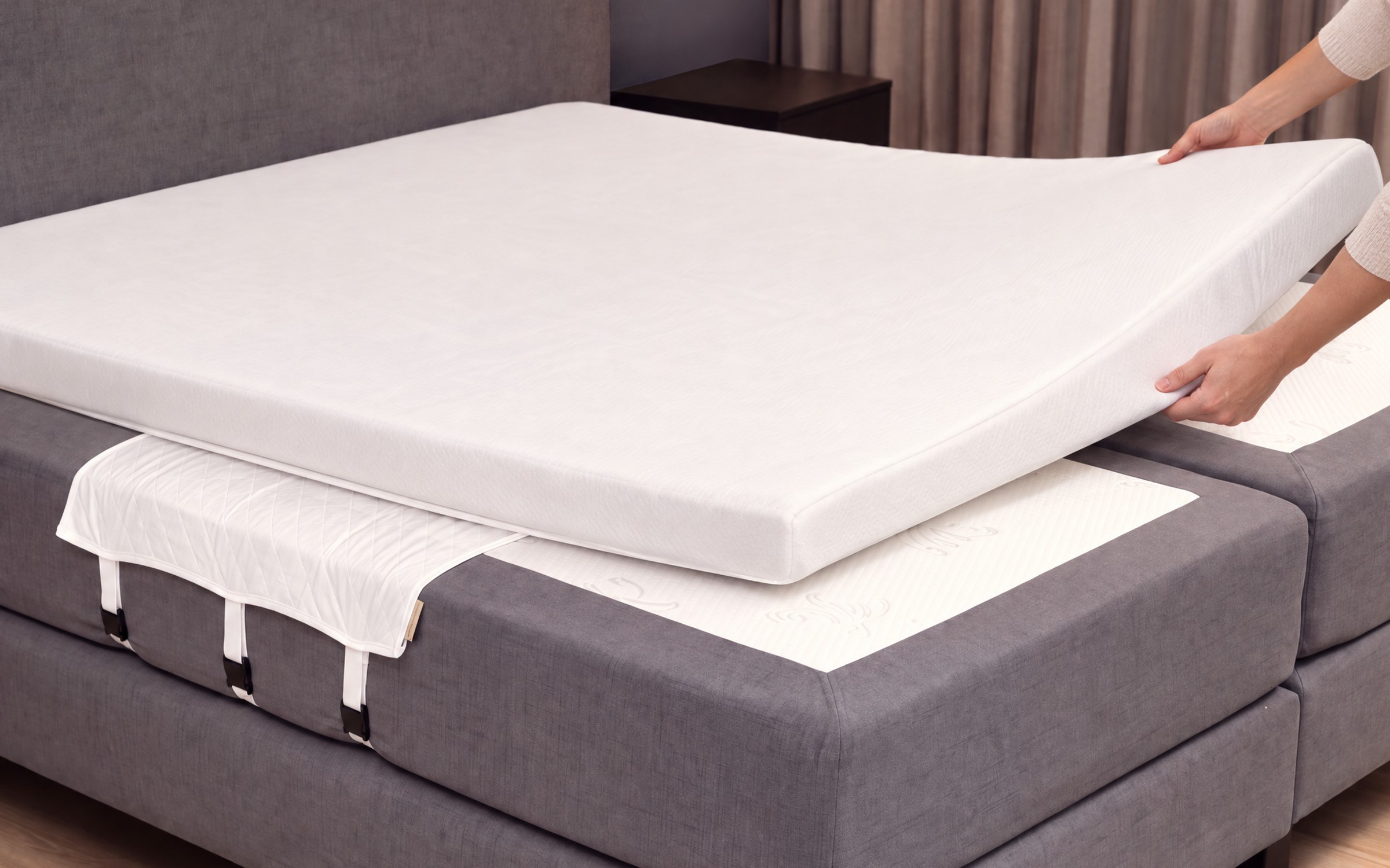 Un surmatelas posé sur les matelas, le Bedbinder dessous avec trois sangles et ses boucles sur le côté