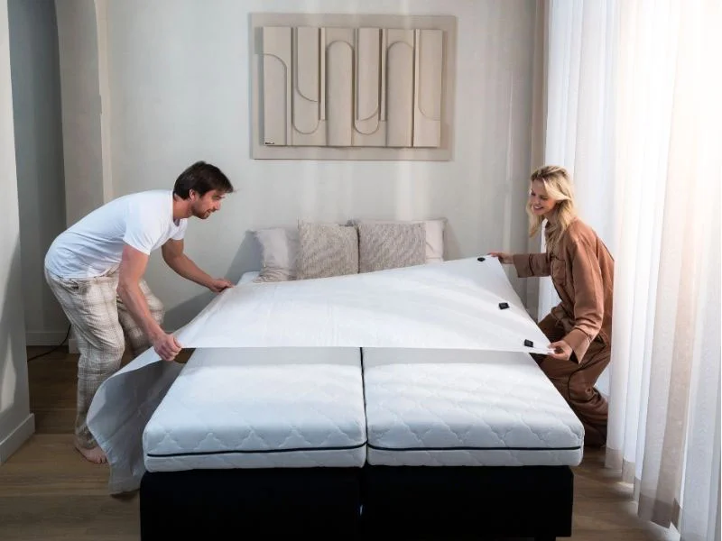 Stel legt de Bedbinder Deluxe over het midden van het bed, waar het meeste gewicht komt