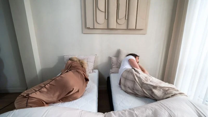 Voor de Bedbinder Deluxe: stel ligt met de rug naar elkaar toe, spleet tussen de matrassen